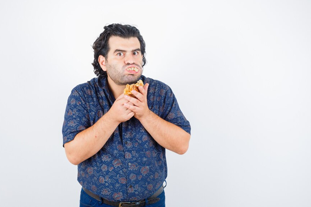 Man with eating disorder holding food, highlighting the need for help at the best de-addiction center in Coimbatore.