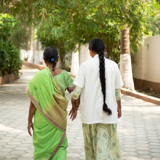 Two individuals walking through the tranquil grounds of Naveen Rehab Center in Coimbatore, symbolizing the supportive journey towards recovery from Rehabilitation Psychiatric Disorders.